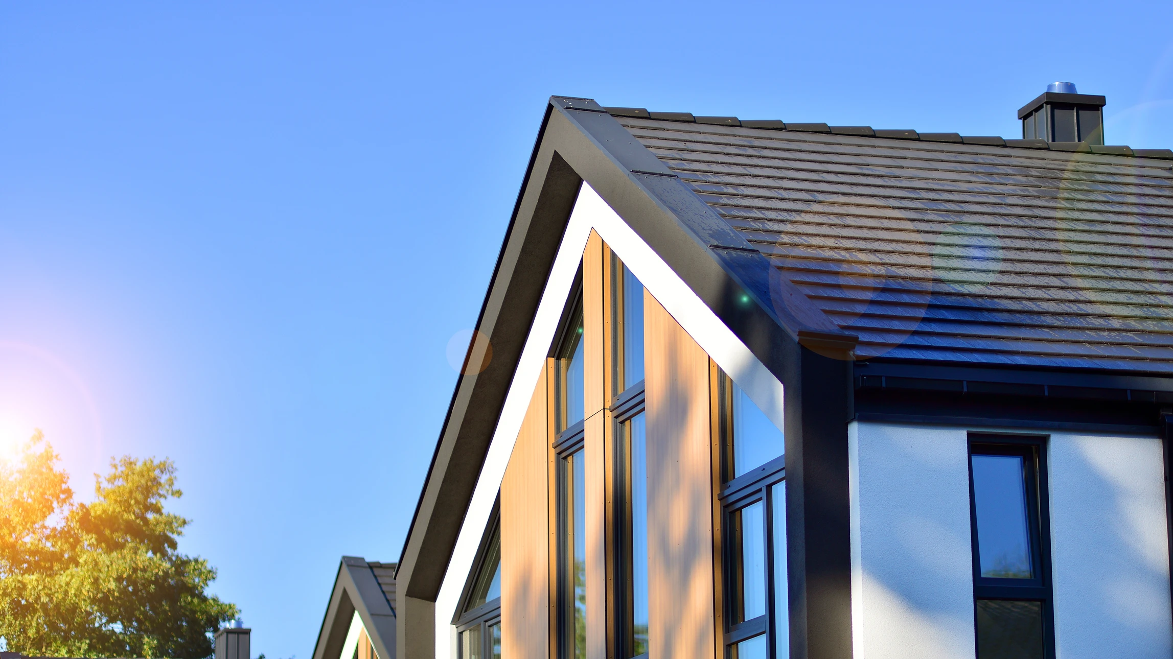 Ouvrier en bâtiment appliquant un enduit sur mur intérieur avec truelle, portant casque orange et combinaison grise